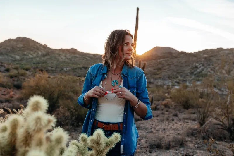 Kaylee in a denim shirt in the desert at sunset